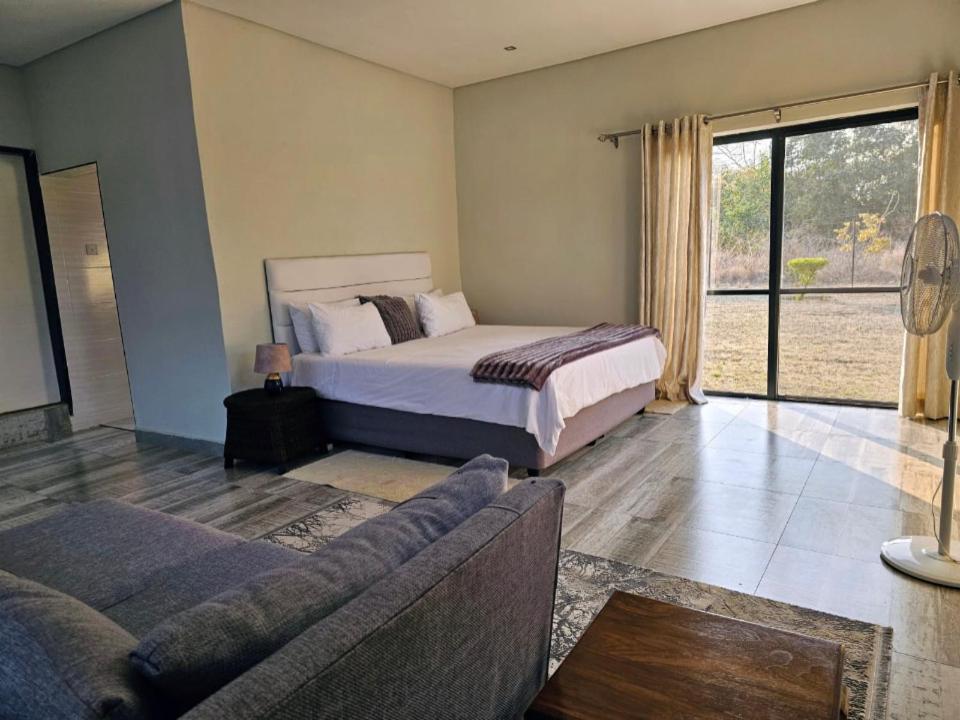 卢萨卡Chuumba Villas的一间卧室配有一张床和一张沙发