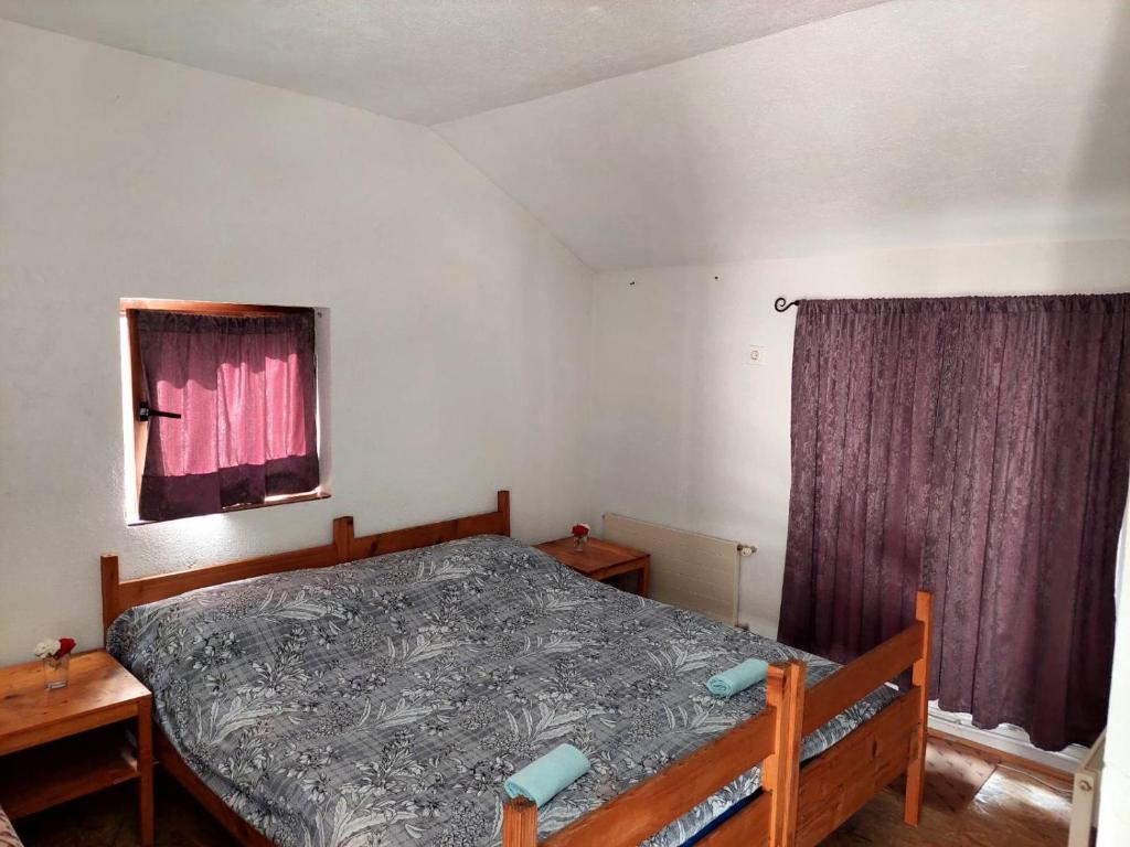 特拉夫尼克33 Lipe的一间卧室配有一张床和一个带紫色窗帘的窗户