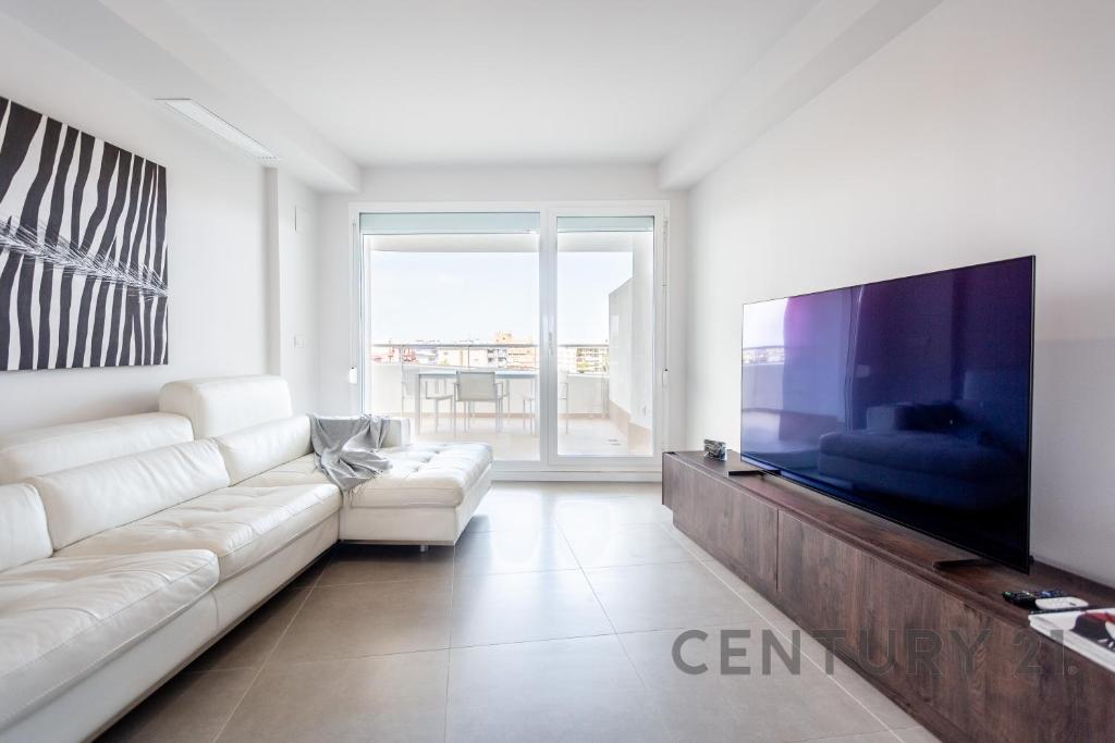 卡耐特蒂贝兰格Apartamento de lujo con 2 habitaciones en Canet d'en Berenguer的客厅配有白色沙发和大电视