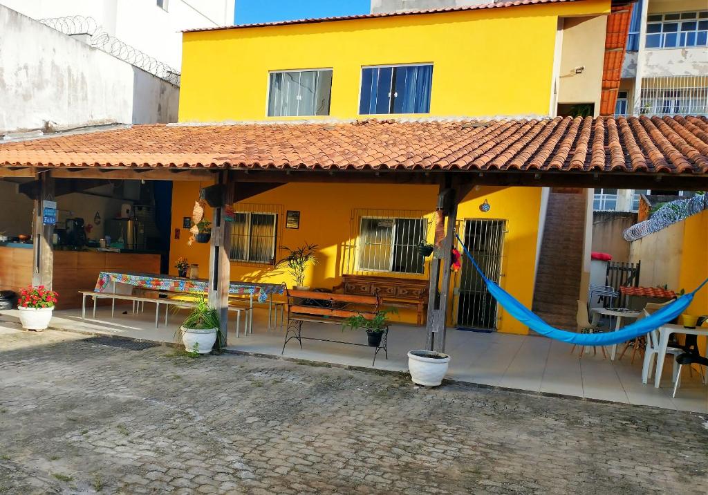 瓜拉派瑞Casa Amarela Hostel的黄色房子前面设有吊床