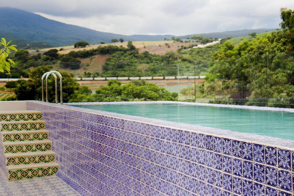 特基拉Hotel Boutique Gloriagave的一个带紫色瓷砖墙的游泳池