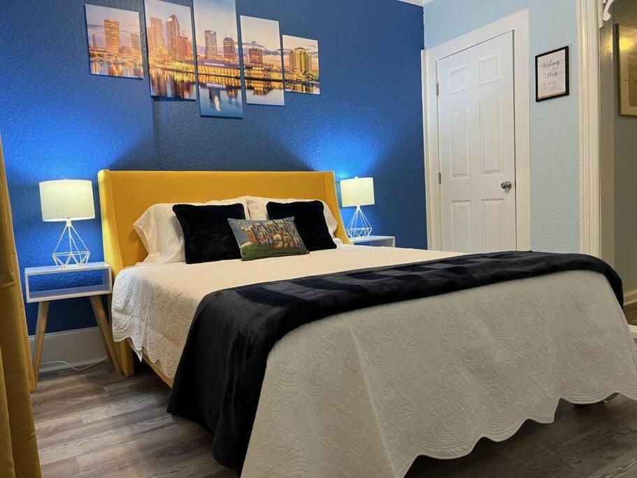 坦帕Luxury Suite by Tampa Convention Center & Hospital的一间卧室配有一张带蓝色墙壁的大床