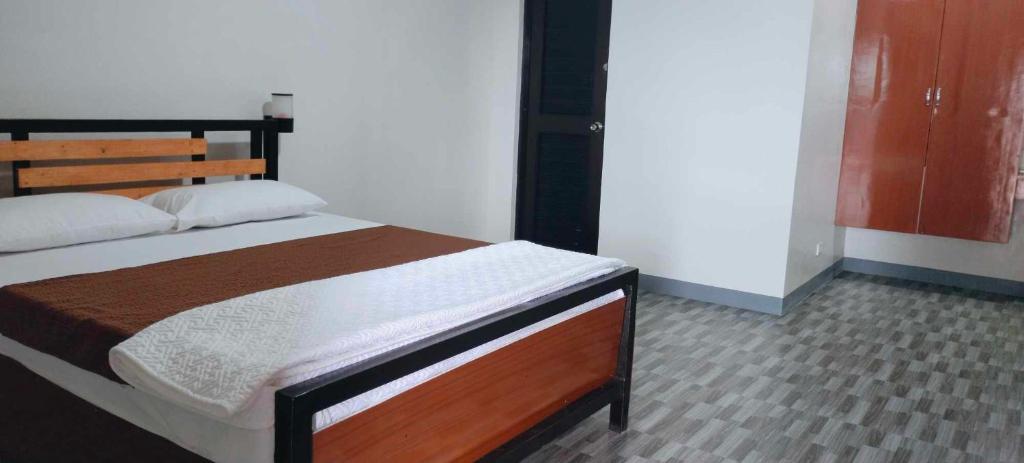 CandelariaMatibag recreational hub resort and hotel的一间卧室配有一张带木制床头板的床