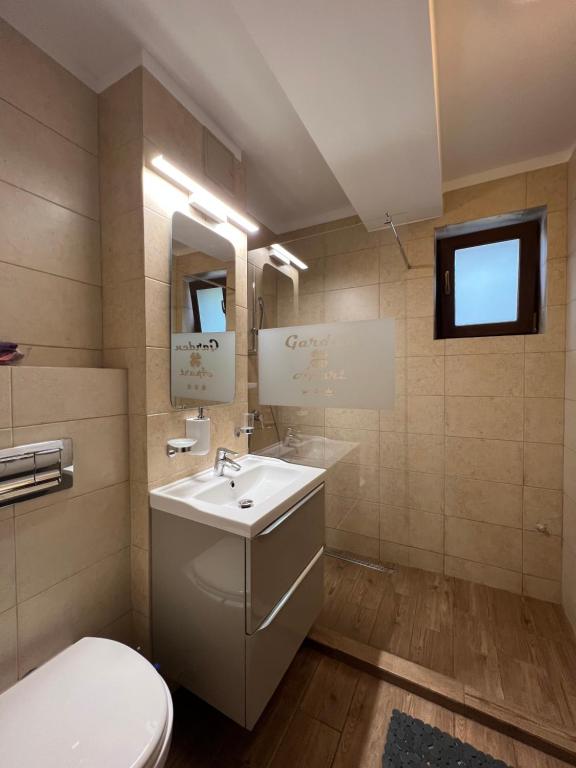 普雷代亚尔Apartamente de inchiriat- Garden Apart Predeal的浴室配有白色水槽和卫生间。