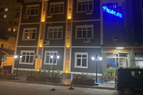 阿达纳Asus Palmiye Otel的建筑的侧面有蓝色标志