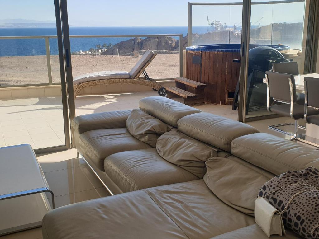 埃拉特Top-Luxury Exclusive Аpt with Jacuzzi in front of the sea的带沙发的客厅,享有海滩美景