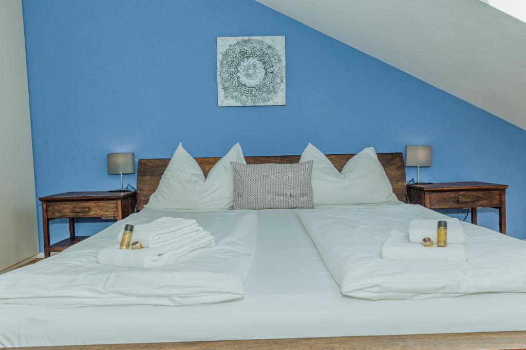 萨尔茨堡arte vida boutique guesthouse的一张白色大床,配有白色枕头和蓝色的墙壁