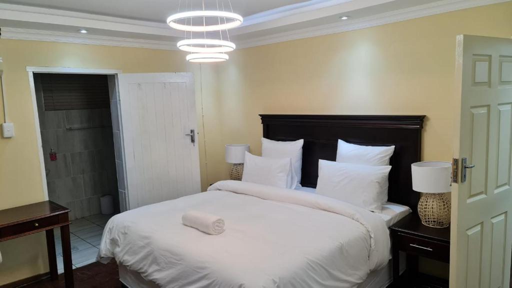 彼得马里茨堡Suprime Hotels and Conference的卧室配有一张带白色床单和枕头的大床。