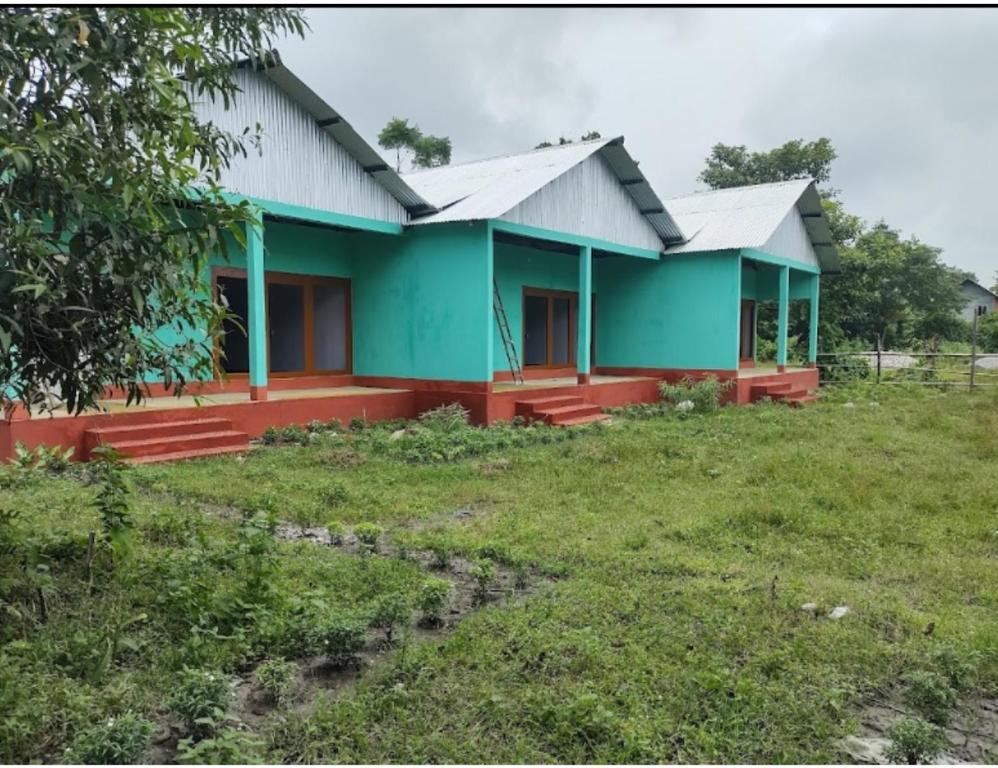 Jyoti GaonMayuri Nature Camp, Barangabari, Assam的院子旁田野的房子