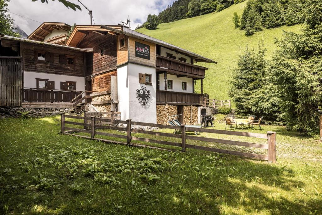 施瓦茨Alpenzauber / Chalet AlmZeit / Almhütte Zillertal的山丘上的房子,前面有栅栏