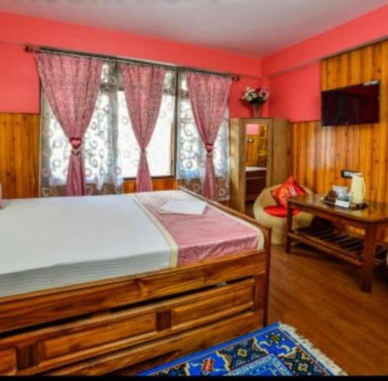 GhumGRG Tharbaling Homestay Darjeeling的一间卧室配有一张床和一张书桌