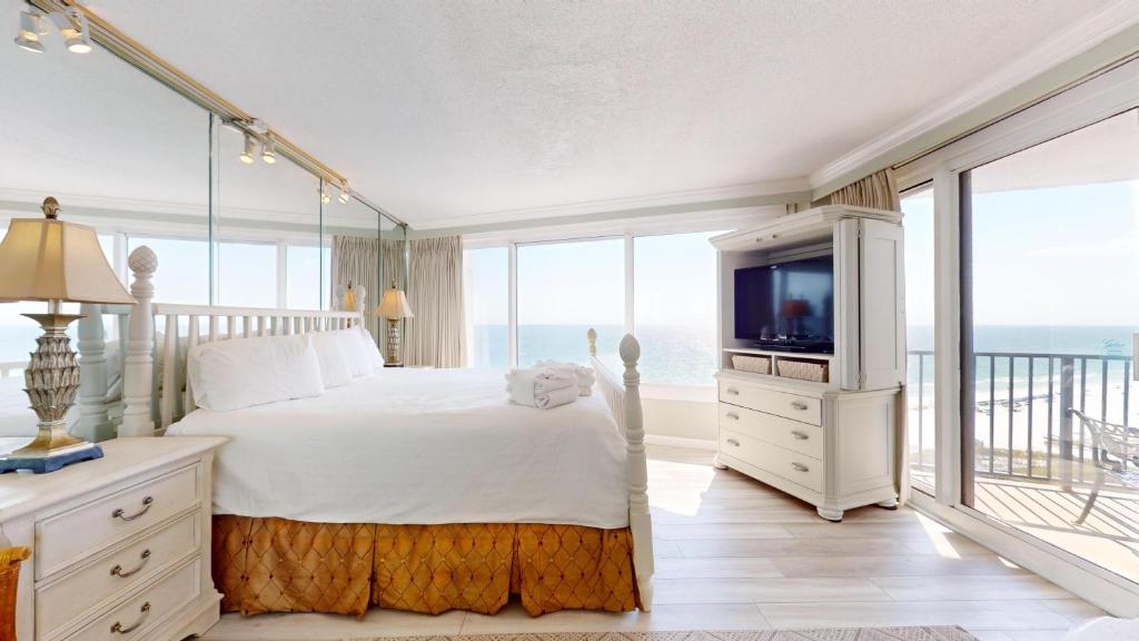 德斯坦Beachside I 4144的一间卧室设有一张床、一台电视和窗户。