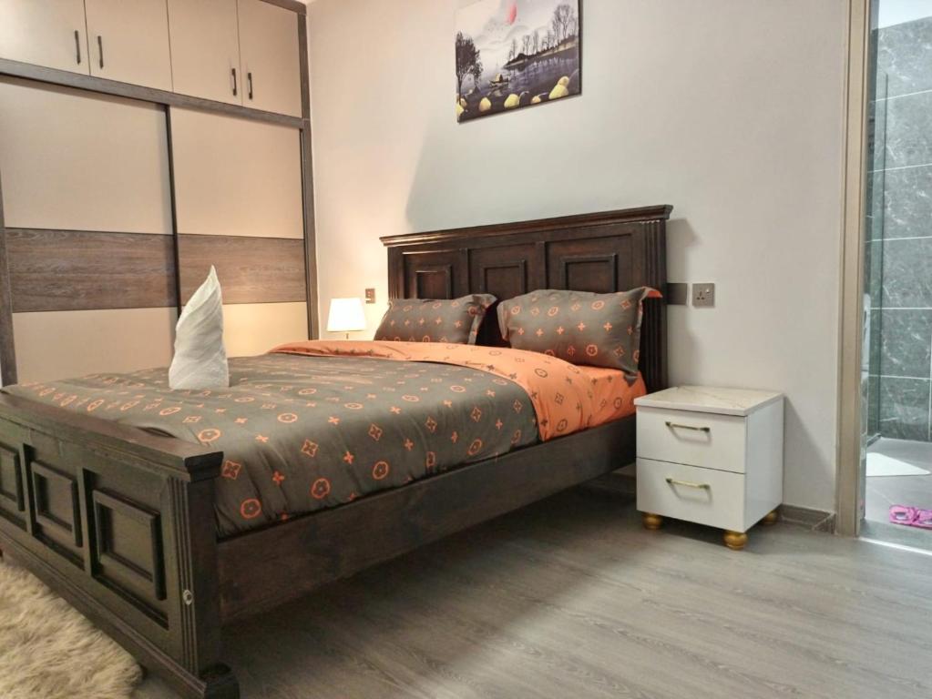 内罗毕New 2 & 3 bedroom Apartment in Kilimani Nairobi with rooftop pool的一间卧室配有一张大床和一个床头柜
