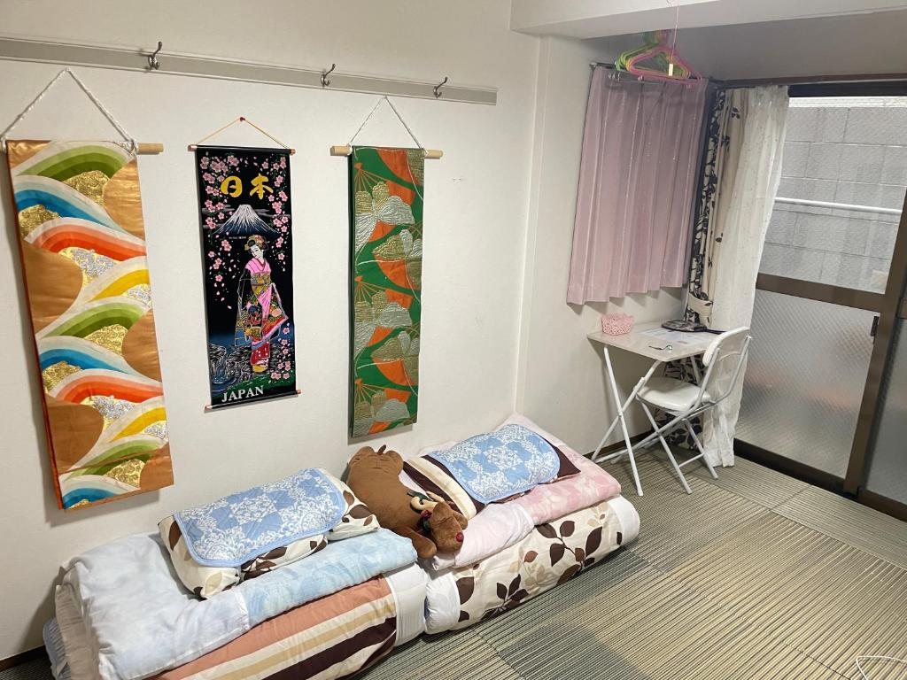 东京新宿の家-畳み3人部屋的一间设有两张床的客房,墙上挂着一幅画