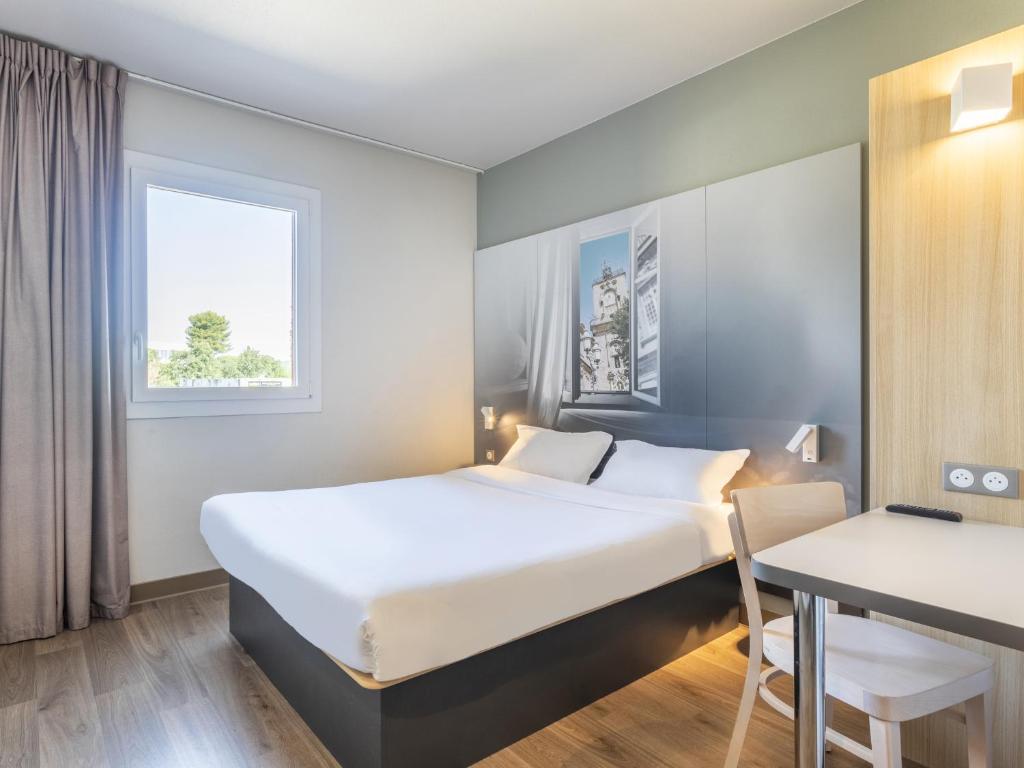 沃内勒B&B HOTEL Aix en Provence Venelles的配有一张床和一张书桌的酒店客房
