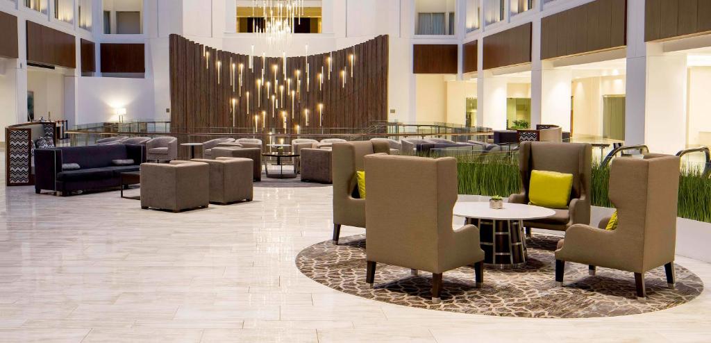 华盛顿华盛顿格兰德凯悦酒店的酒店大堂设有桌椅和吊灯。