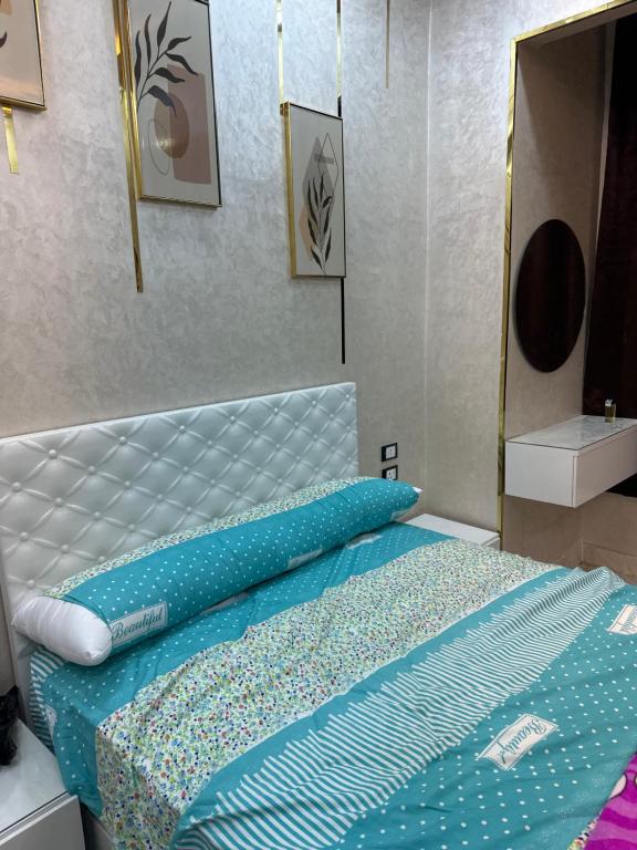 قويسنا محافظة المنوفيه的一间卧室配有一张带蓝色床单和镜子的床