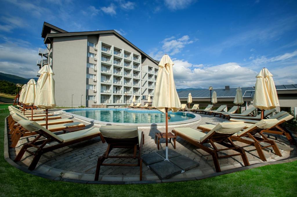 丘斯滕迪尔Парк хотел Кюстендил的酒店前方的游泳池配有椅子和遮阳伞