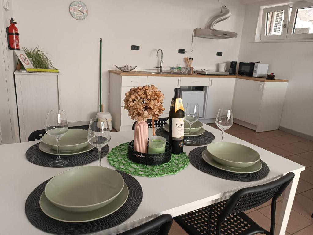 新戈里察Apartma 31的一张带盘子和玻璃杯的桌子和一瓶葡萄酒