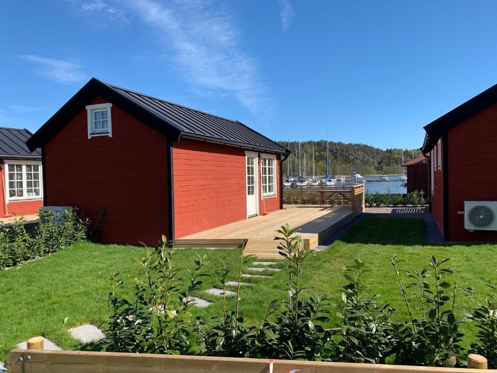 南雪平Lyxiga stugor med sjöutsikt的一座红色的房子,设有甲板和庭院