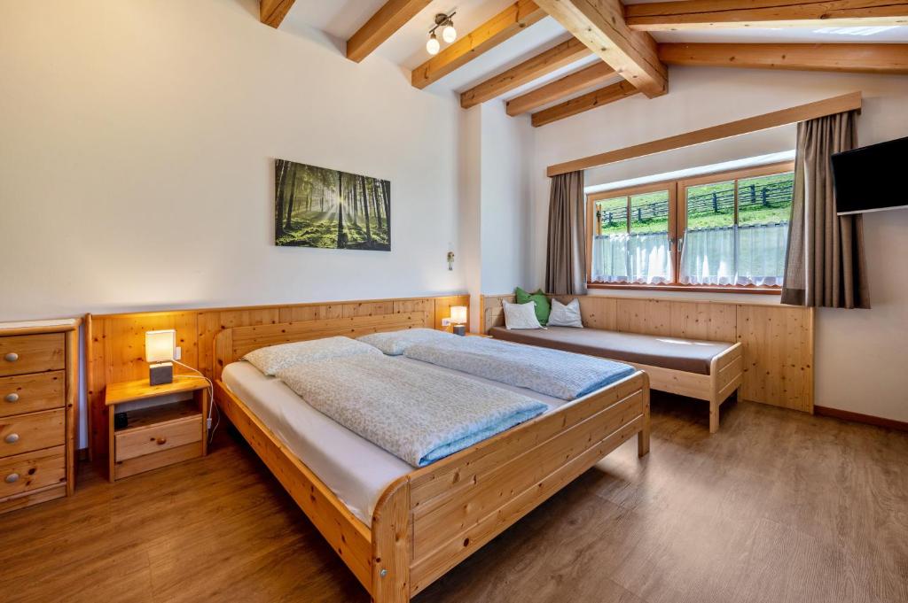 瓦尔道拉Urthalerhof Apt Landhaus的一间卧室设有一张大床和一个窗户。