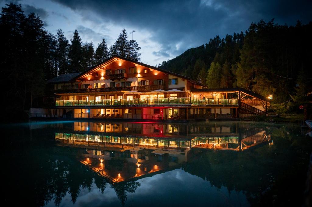 圣维吉利奥Hotel Lago della Creta的一座在夜间水面上灯亮的大建筑