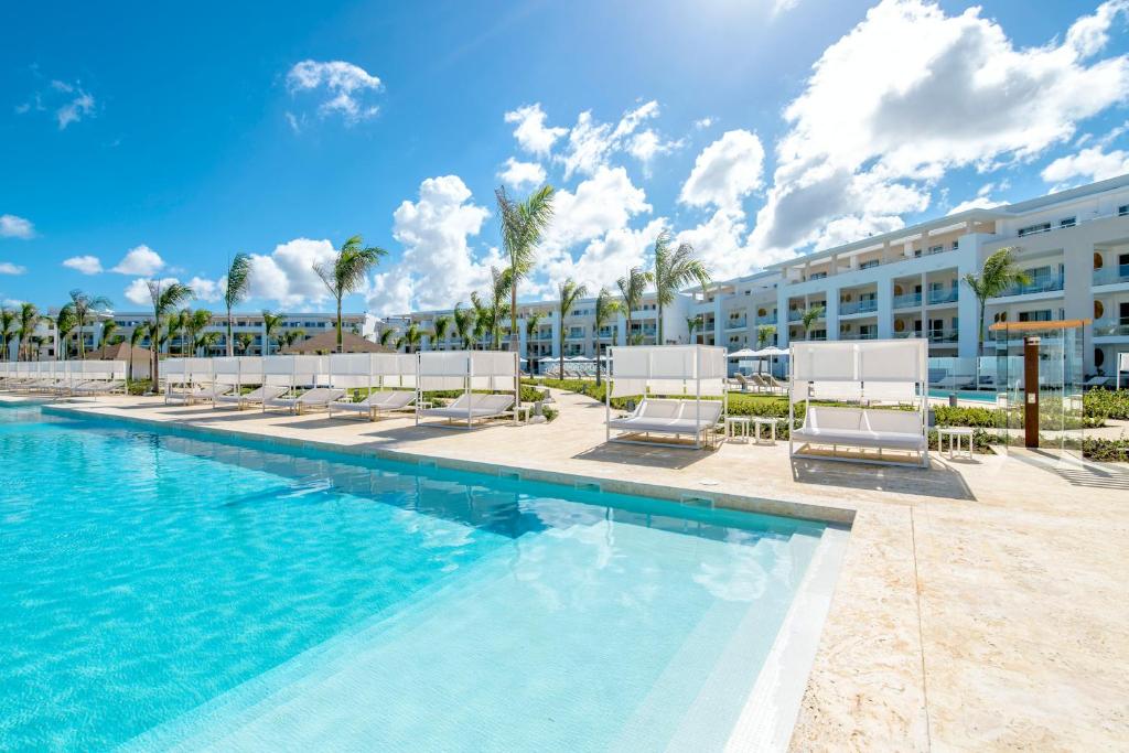 蓬塔卡纳Paradisus Grand Cana, All Suites - Punta Cana -的一座带躺椅的度假游泳池和一座建筑