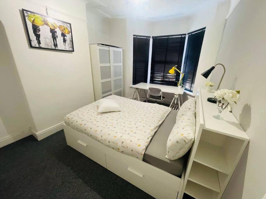 利物浦Stunning 4-BR Home near City Centre的白色卧室配有床和书桌