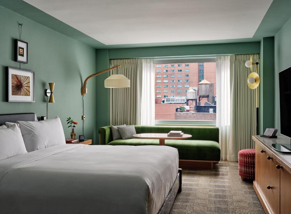 纽约Romer Hell's Kitchen的酒店客房设有床、沙发和窗户。