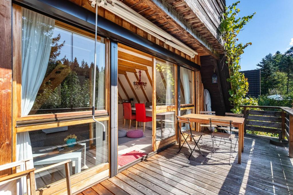 希格斯多夫Charmantes Ferienhaus mit Garten的木制甲板上配有桌椅