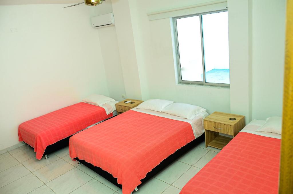 蒙特里亚Hermosa casa en Costa de Oro的带3张红色床单和窗户的房间
