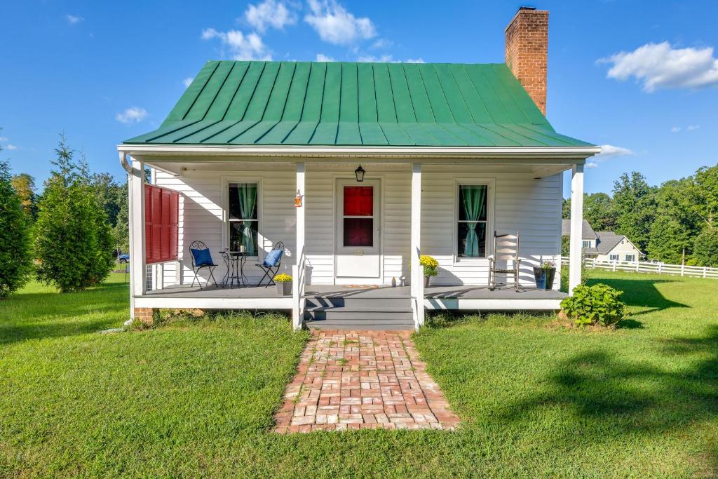 中洛锡安Tranquil Cottage in Virginia Countryside with Pond!的一座白色的小房子,设有绿色屋顶