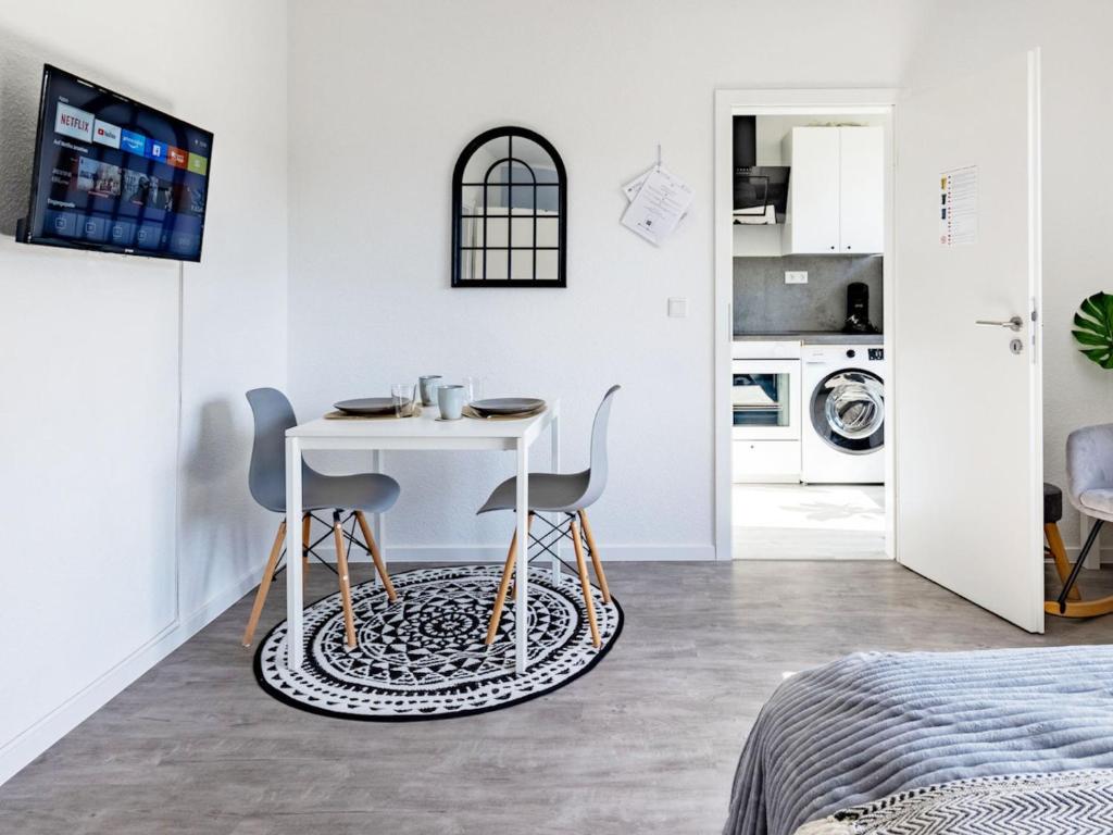 埃森# VAZ Apartments E01 Küche, TV, Netflix, ca 15 Min Messe u HBf的白色的客房配有桌子和两把椅子