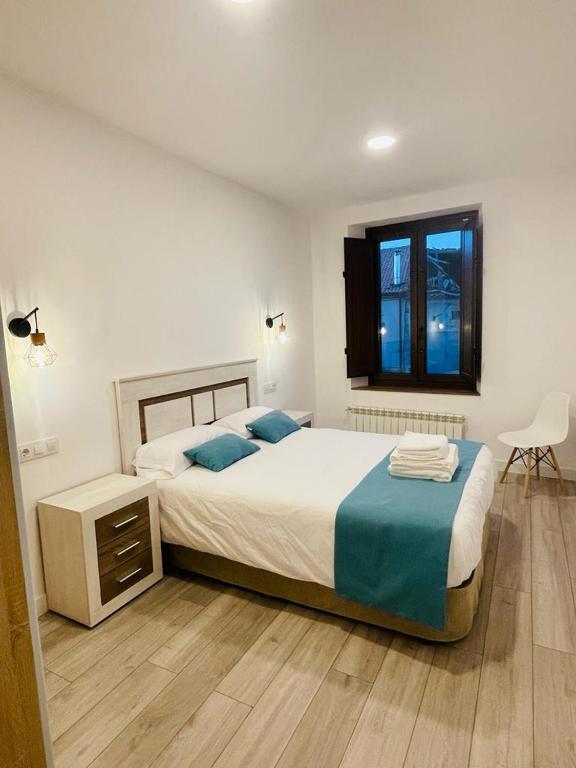 杜鲁埃洛德拉谢拉Apartamentos Rurales La Plaza 2的一间卧室设有两张床和窗户。