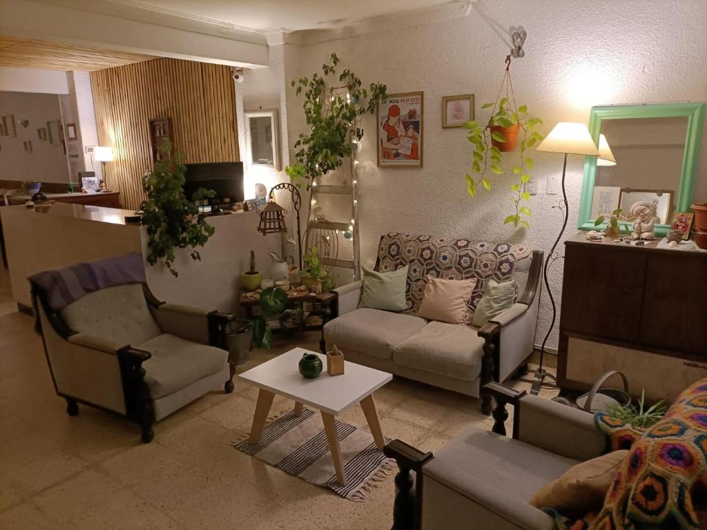 马德普拉塔Casa Nanet Hotel的客厅配有两张沙发和一张桌子