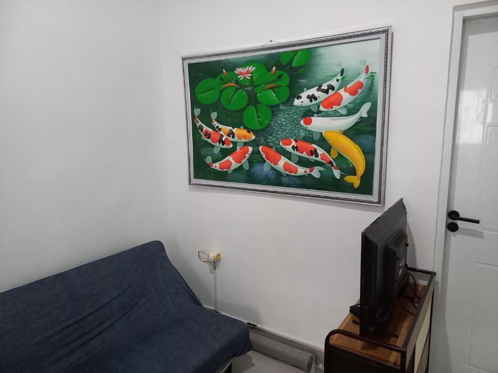 苏加武眉Villa Akela Sukabumi的一间墙上有画作的房间和一台电视
