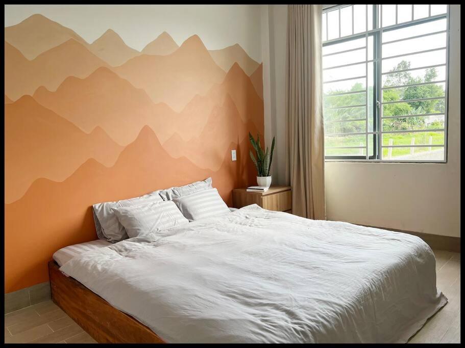 Trà VinhVilabasi Cổ Tháp的卧室配有一张大床,墙上挂有山壁画