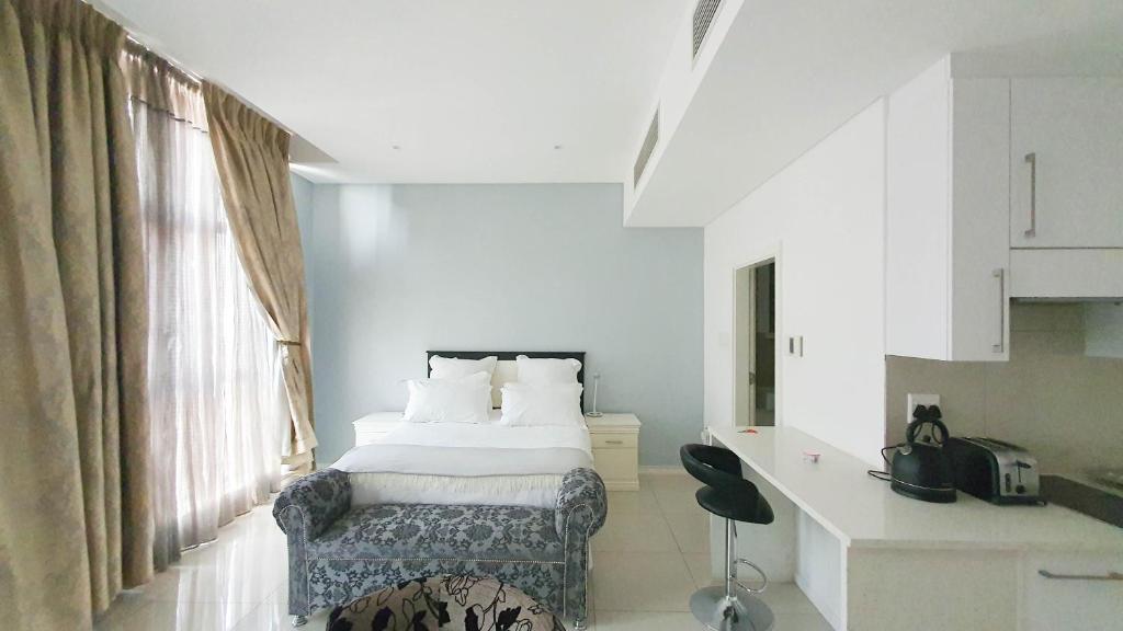 哈博罗内iTowers Studio-Suite的一间卧室配有一张床、一张书桌和一个窗户。
