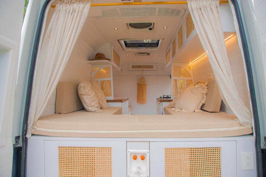 波哥大Campervan Bogota Rolling Suite的配有床和窗帘的露营车内部景色