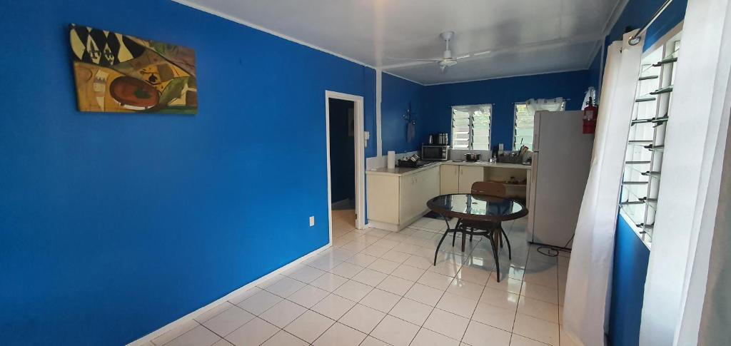 阿皮亚Lynn's Getaway Guest House的蓝色的客房设有桌子和厨房