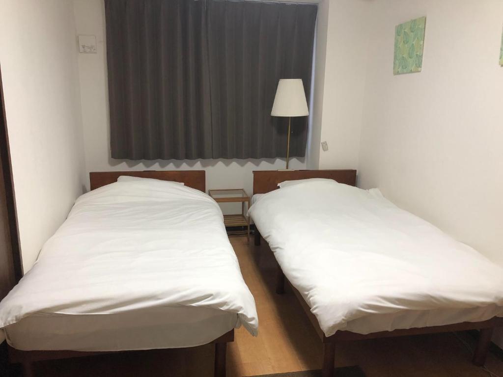 大阪HOTEL LUCKY - Vacation STAY 49954v的配有白色床单的客房内的两张床