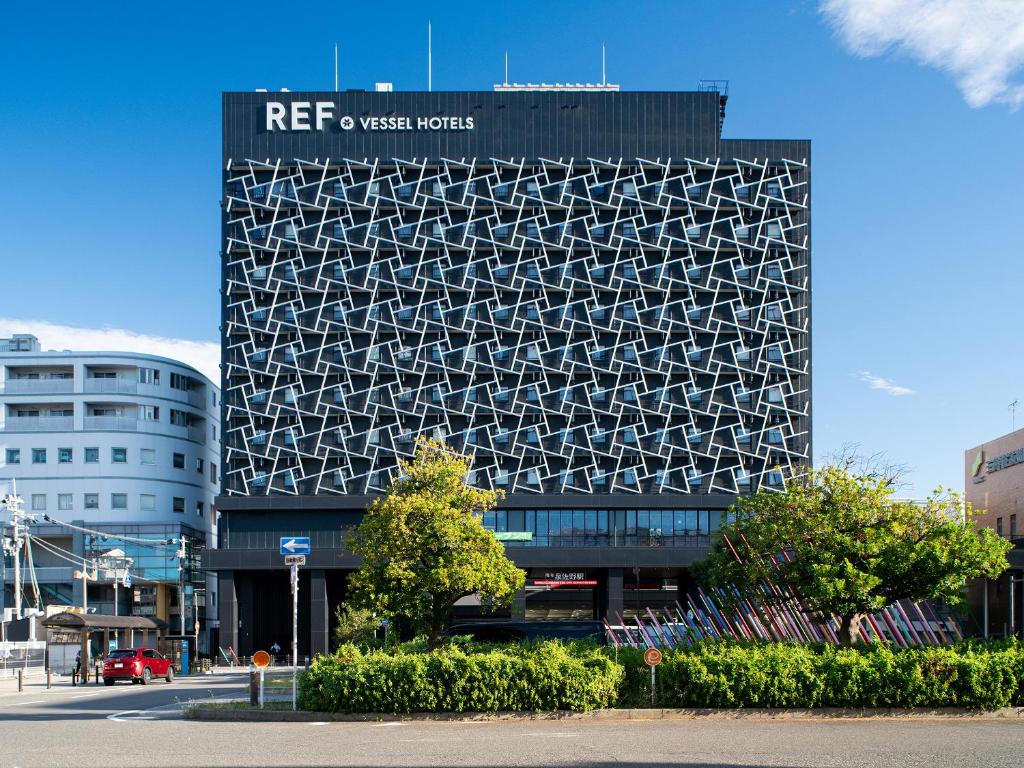 泉佐野REF Kanku-Izumisano by VESSEL HOTELS的建筑的侧面有标志