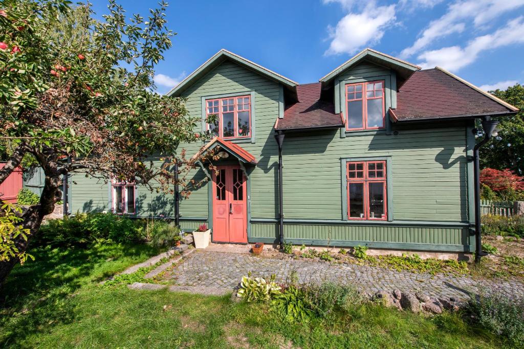 龙讷比Modern house in Ronneby near lake and sea的一座带红色门的绿色房子