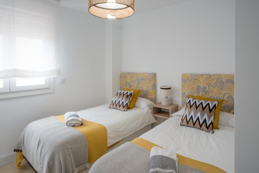 塞维利亚Luxury Apartment Free Parking的一间卧室配有两张床和吊灯。