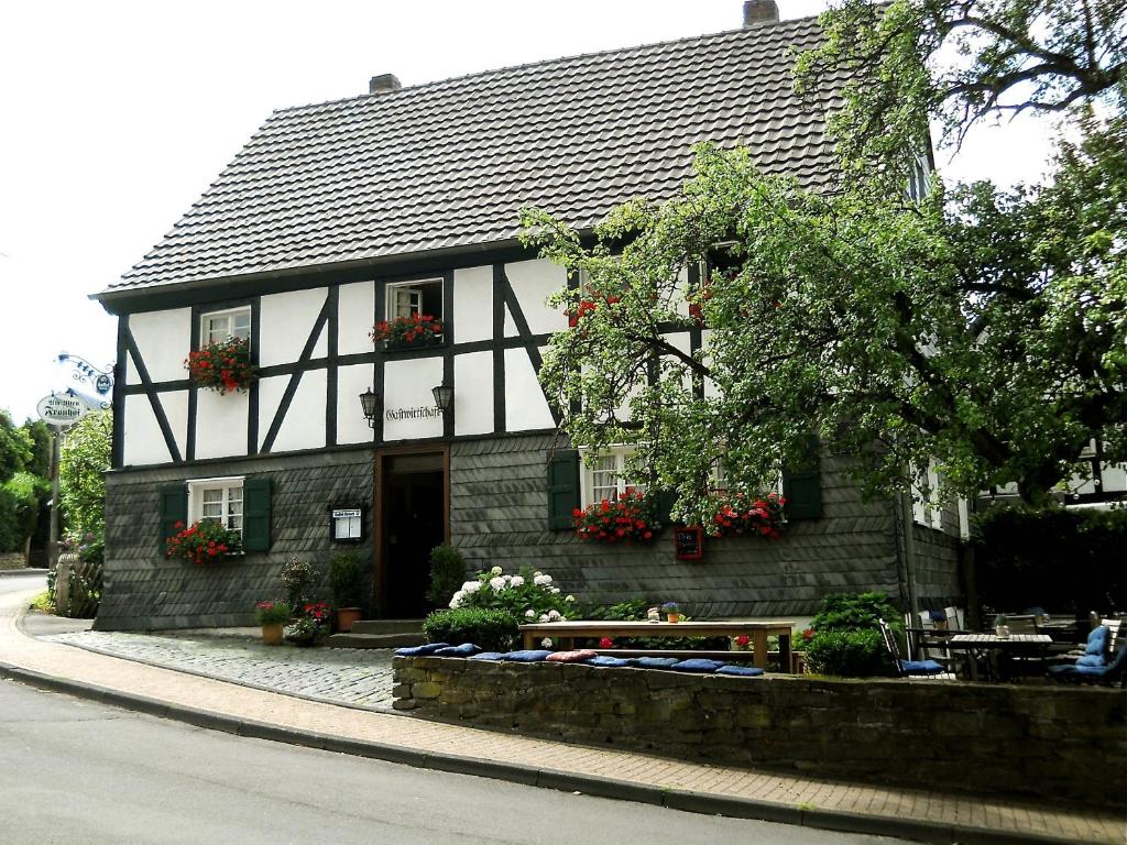 贝尔吉施格拉德巴赫弗朗霍夫酒店的黑白的建筑,前面有一张桌子