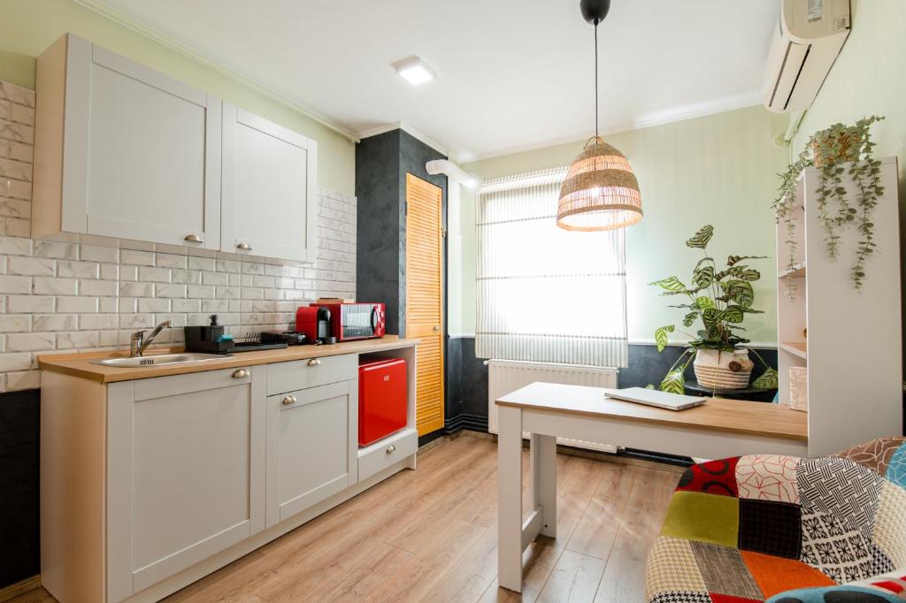 蒂米什瓦拉NEW Iorga3 OldCity SelfCheckIn的厨房配有白色橱柜和桌子