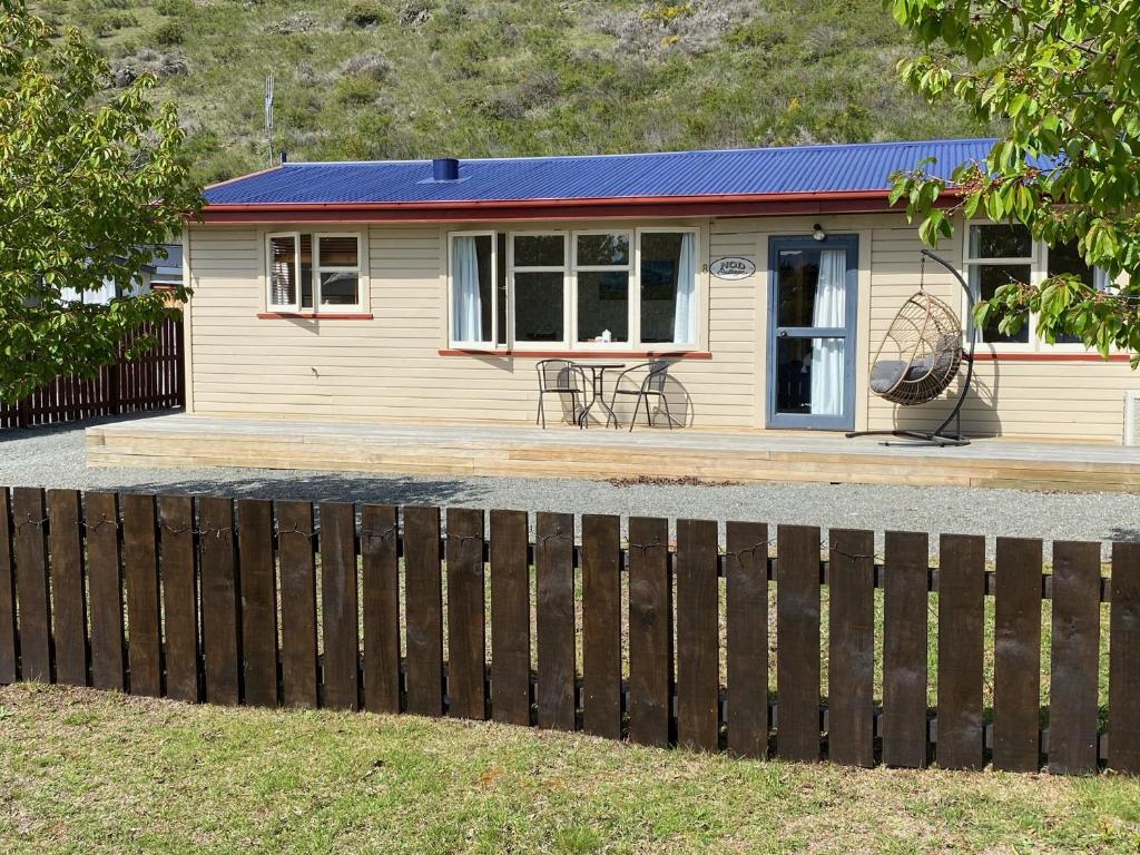奥玛拉玛Cosy 1960's Kiwi Holiday House的前面有围栏的小房子