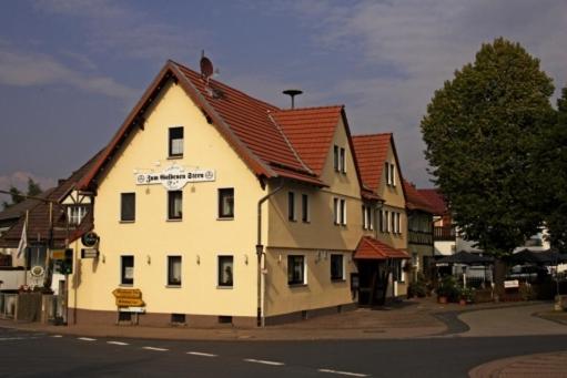 Großalmerode佐姆迦登斯蒂姆酒店的一座白色的大建筑,有红色的屋顶