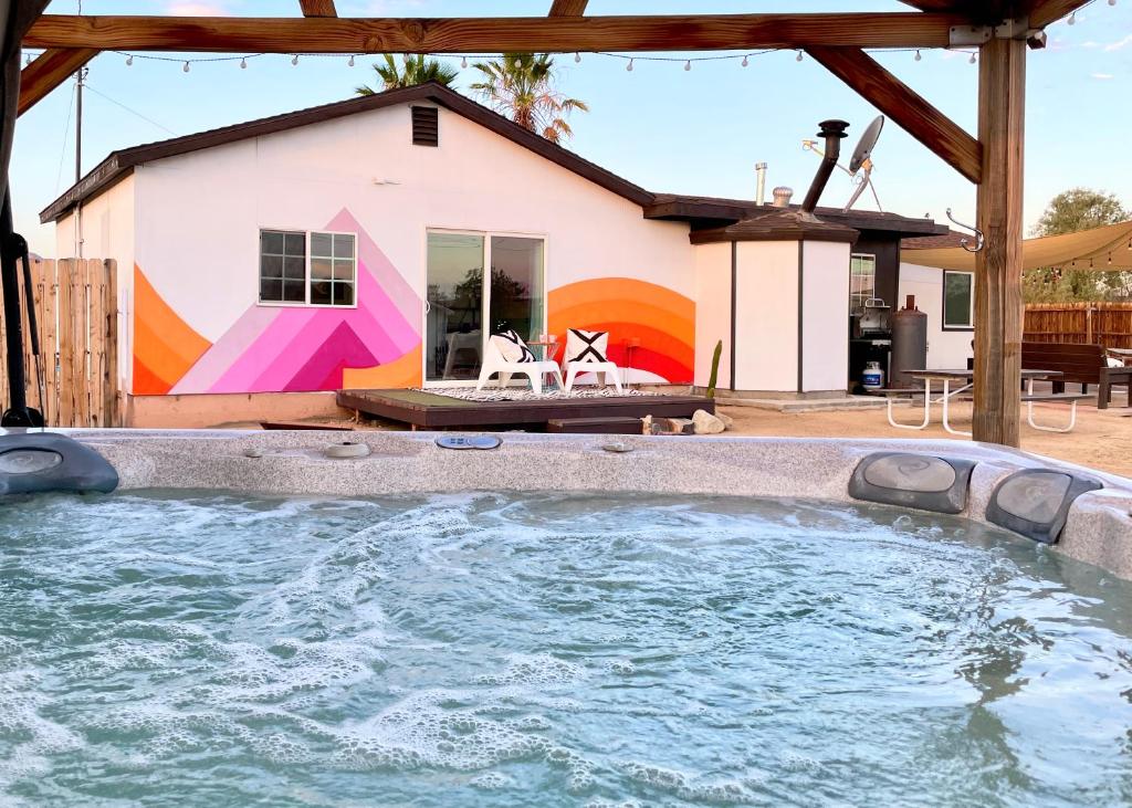 约书亚树Twin Palms Desert Getaway - Jacuzzi, Fire pit, Meditation room & more的一座房子前面设有一个大型游泳池