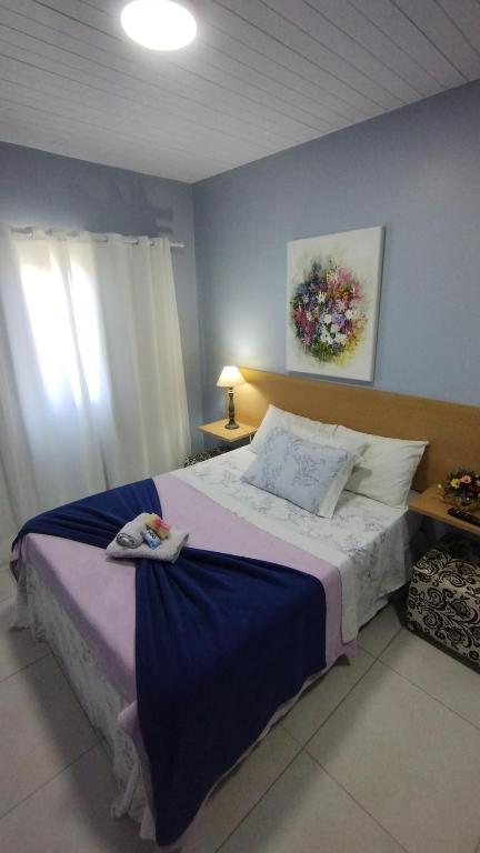 弗洛里亚诺波利斯Solar da Lorena的一间卧室配有一张带蓝色墙壁的大床